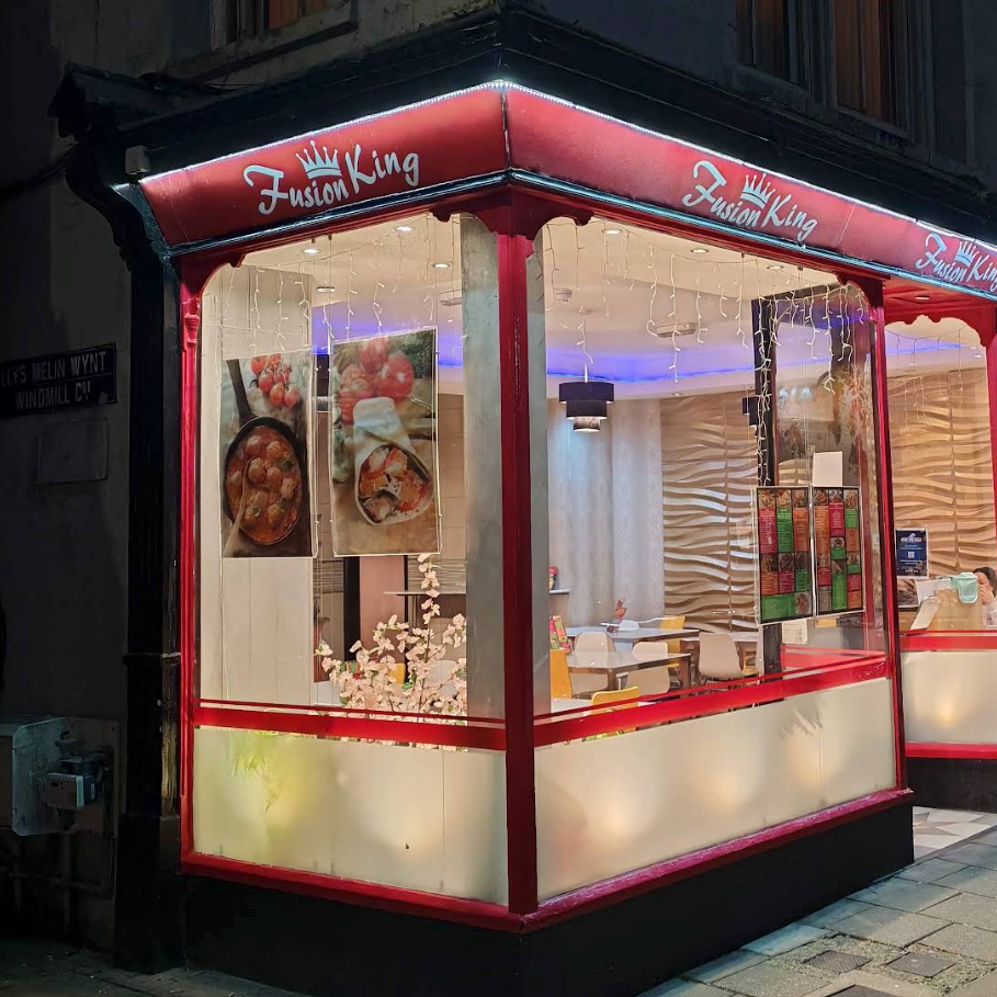 Fusion King shopfront at 31 Eastgate, Aberystwyth, lit up at night